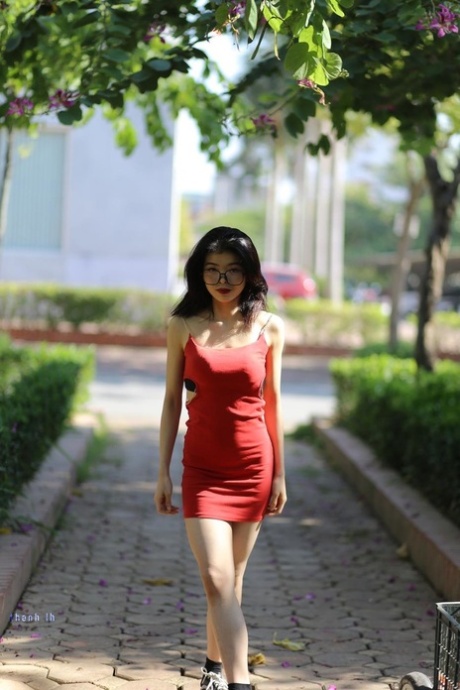 Little Asian doll with eyeglasses Irena poses in her tight red dress