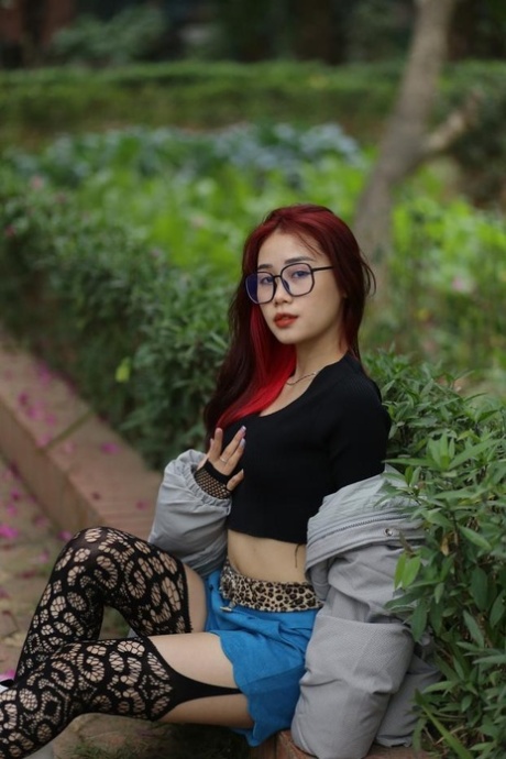 Redheaded Asian girl with glasses Wanara poses in her slutty outfit outdoors