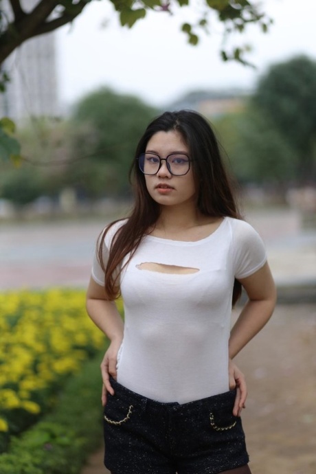 Nerdy Asian model Natalia posing in her provocative outfit outdoors