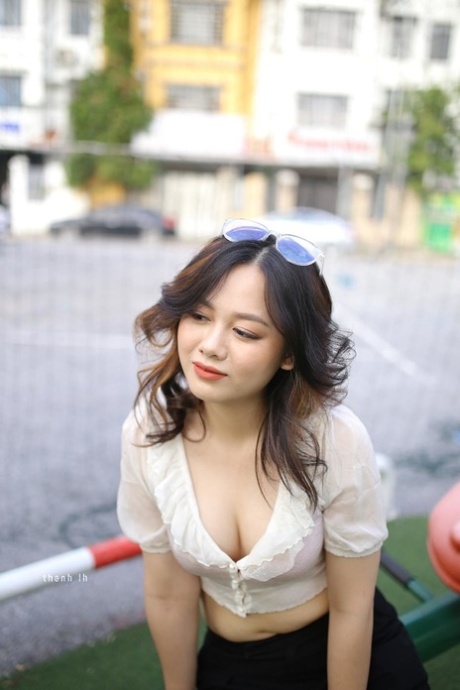 Gorgeous Asian girl exposes her sexy cleavage while posing in public