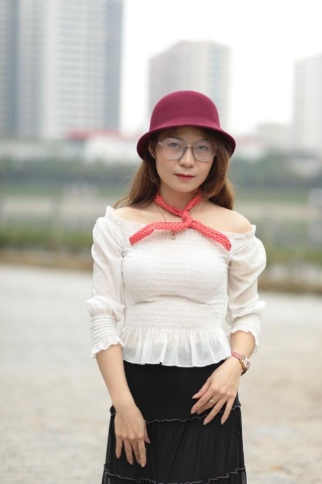 Little Asian girl with eyeglasses posing in her lovely outfit in public