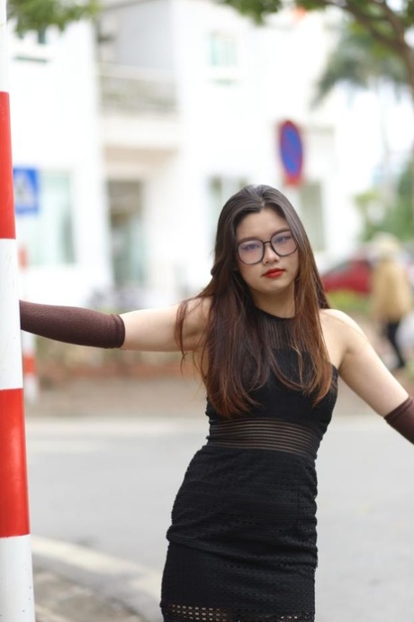 Glamour chica asiática con gafas Natalia posa en su traje sexy en público