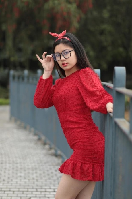 Nerdy Asian girl Natalia posing in her elegant red dress in public