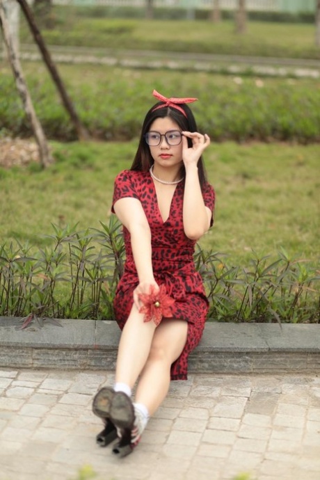 Petite fille asiatique à lunettes Natalia posant en robe rouge et talons à l