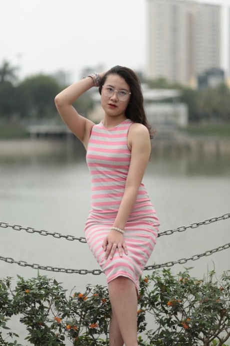 Glamorous Asian model Elena posing in her sexy dress with stripes in public