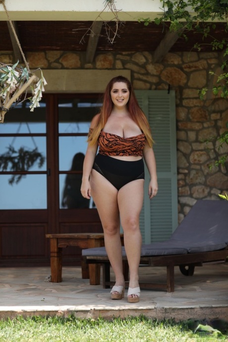 Die rothaarige fette Lucy Vixen zieht ihr Oberteil aus und zeigt ihre riesigen natürlichen Titten