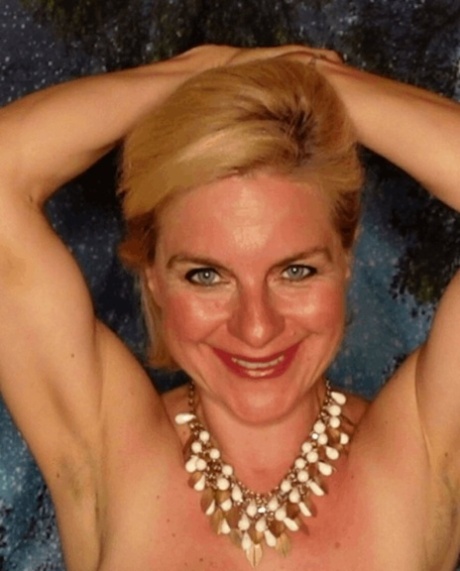 Une amatrice blonde et mûre caresse son énorme jugulaire et pose dans un soutien-gorge en dentelle.