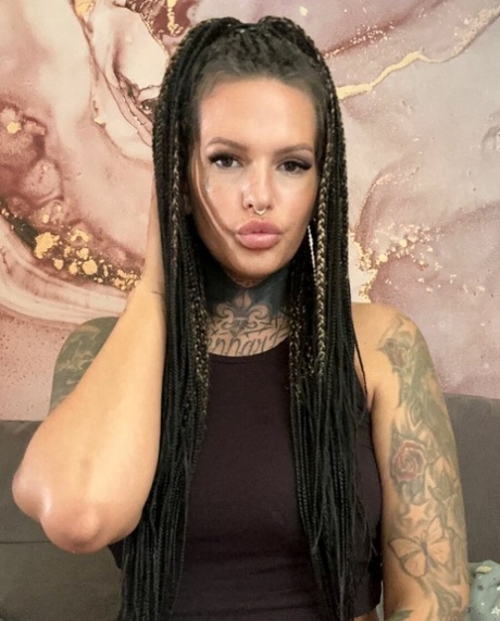 Une jeune fille tatouée montre son gros cul dans un tease chaud en lingerie noire