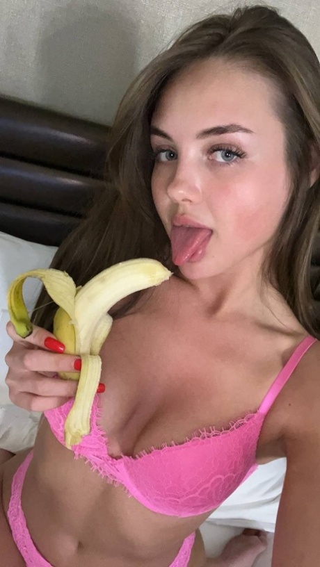 Sexy OnlyFans tiener Vi Angel poseert in haar roze lingerie terwijl ze een banaan eet