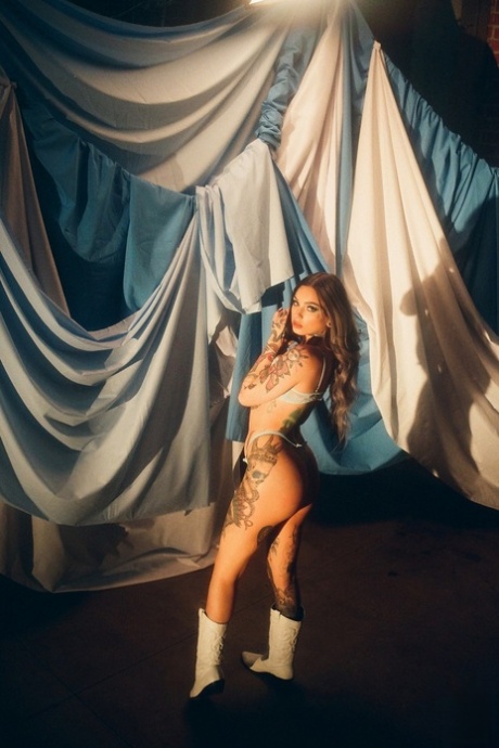 Inked beuaty Taylor White reveals her natural figure and poses among sheets