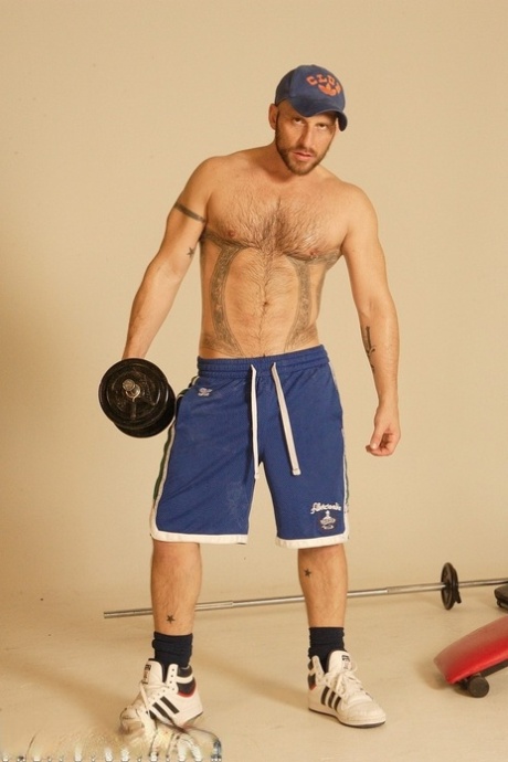 Strong hairy gay athlete Aitor Crash strips naked while lifting weights