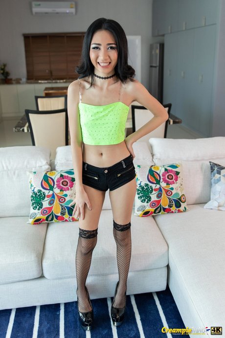 Asiática magrinha faz um striptease escaldante com meias e saltos altos