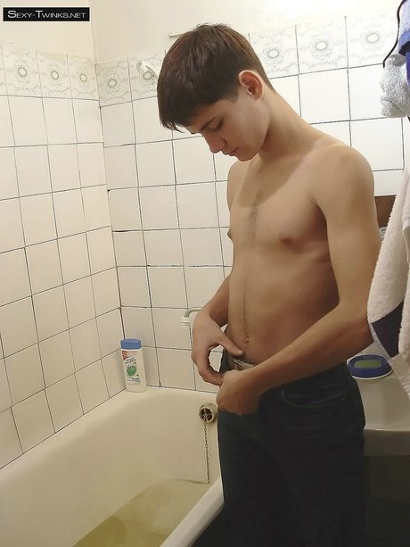 Schöne Brünette Twink posiert nackt und masturbiert in der Badewanne