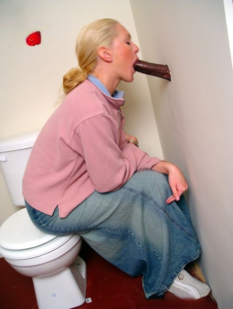 Blondes Mädchen Jamie sitzt auf der Toilette und bläst einen schwarzen Gloryhole-Schwanz