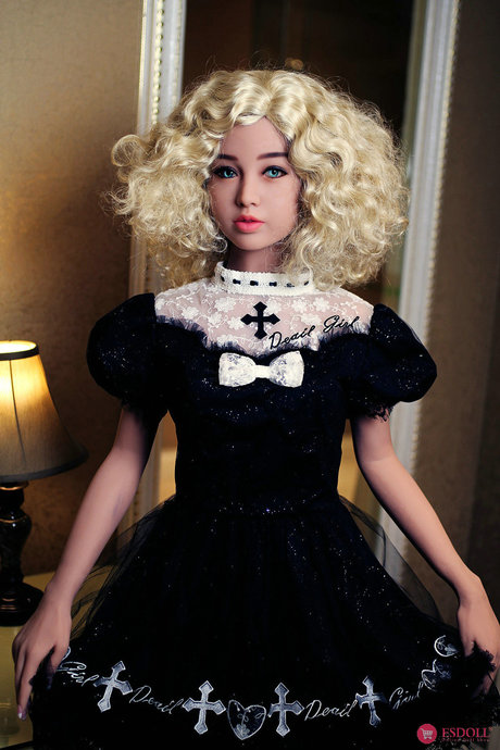 La jeune poupée sexuelle en silicone Lily pose dans sa magnifique robe noire et ses talons.