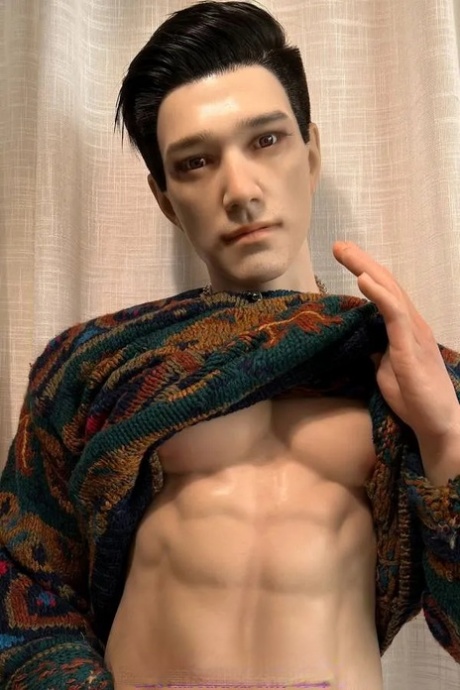 Brunette male sex doll Bertin lifts his sweater and shows his six pack