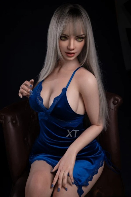 Glamorous blonde sex doll Phoebe loses her blue dress and poses naked