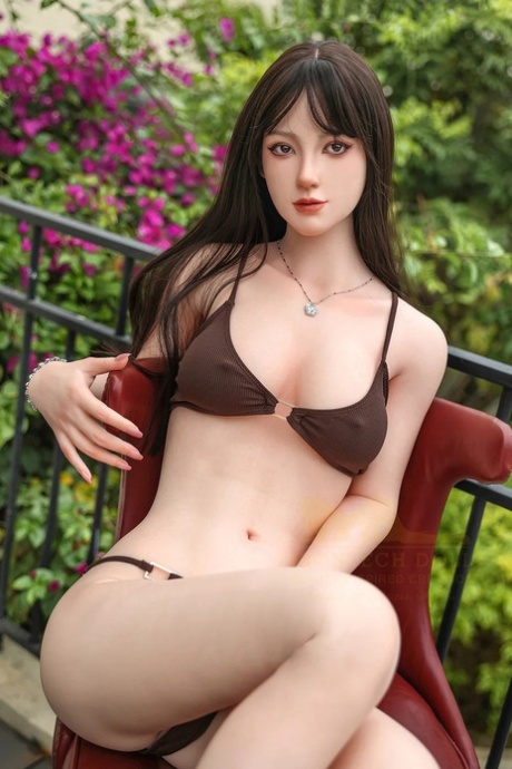 Dark-haired silicone sex doll poses in her bikini and strips outdoors