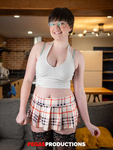 Short haired teen in glasses Kitty Kunt displays her big tits and bubble ass