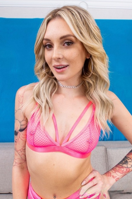 Petite blonde Charlotte Sins posing in her hot pink lingerie in a solo