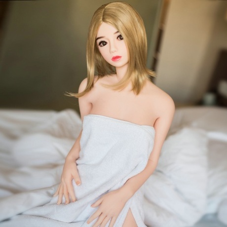 Tiny silicone sex doll Boris loses her nightgown and poses naked in a solo