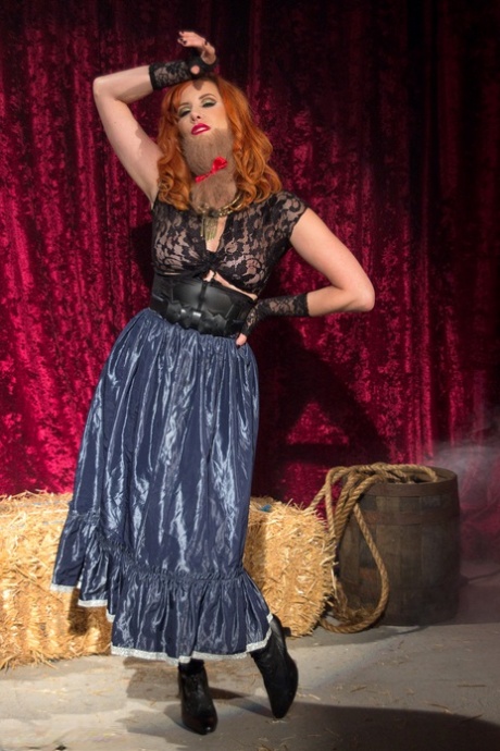 Redheaded femdom Maitresse Madeline Marlowe poses in her black lingerie