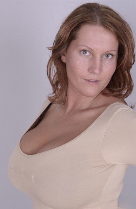 Laura Orsolya, uma euro-mãe alta, brinca com as suas mamas naturais enquanto se despe