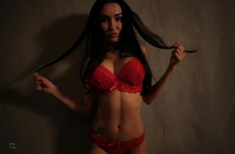 Una ragazza europea si spoglia in modo seducente dalla lingerie rossa per rivelare le tette grosse