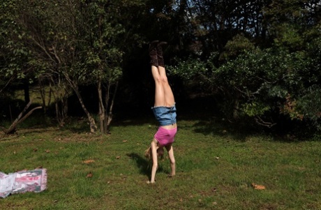 Акробатический подросток Адди Кейт демонстрирует свое худое тело и игрушки на улице