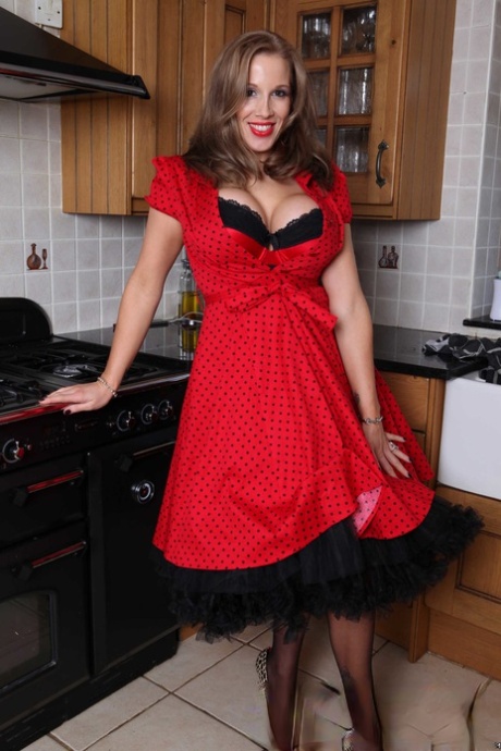Rebecca More, femme au foyer plantureuse, se déshabille en lingerie et pose dans la cuisine.